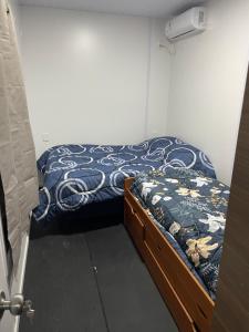 a small bedroom with a bed with a blue blanket at Guazuvira nuevo, sandú coast in Guazuvira