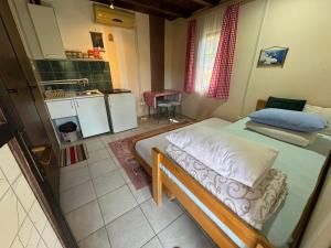 a small bedroom with a bed and a kitchen at Vikendica Vučetić Loznica in Budimlija