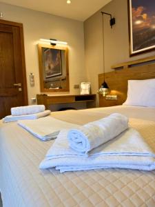 a hotel room with two beds with towels on them at Armenopetra View Gerolimenas in Gerolimenas