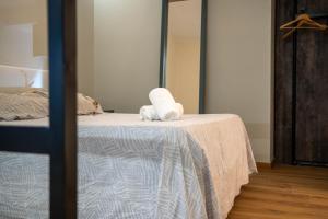 a white stuffed animal sitting on top of a bed at Apartamento Vermú in Guadix