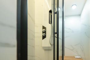 a shower in a bathroom with a glass door at Apartamento Vermú in Guadix +3 photos