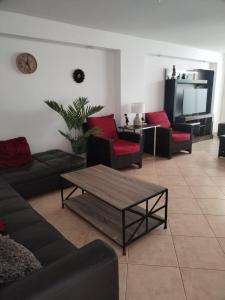 ein Wohnzimmer mit Sofas und einem Couchtisch in der Unterkunft Departamento luminoso frente de la playa Huanchaco in Huanchaco