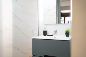a bathroom with a white sink and a mirror at Apartamento Vermú in Guadix