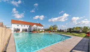 a large swimming pool in front of a house at Lakeside Retreat at Veluwe in Nunspeet