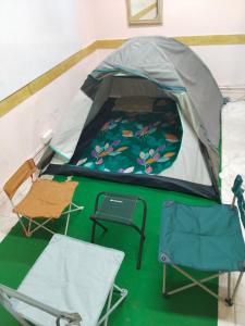 a tent with a bed and two chairs in it at WISHTREE CORPORATE MENS only DORMITORY FOR TECHIES AND Trainees in Chennai +37 photos