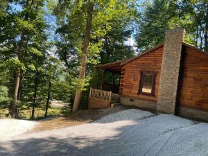 eine Holzhütte mit einer Bank im Wald in der Unterkunft "Alpine Hills" Cozy Hideaway RRG Cabin w/ Hot Tub in Stanton