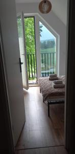 a bedroom with a bed and a view of a balcony at Domek Noclegowy JoWish in Strachocina
