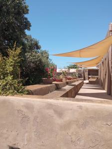 a row of benches with awnings on a sidewalk at Dammuso le Vigne in Pantelleria
