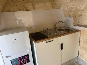 a small kitchen with a sink and a refrigerator at Largo Spani 15 in Veglie