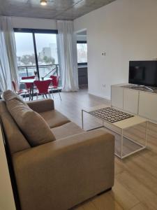 a living room with a couch and a tv at Depto Junin zona Residencial in Junín