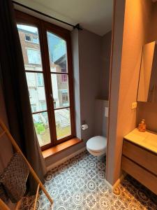 a bathroom with a toilet and a window at Le Piercot in Liège