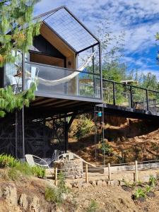 NemocónにあるVive Rela Tiny Housesの丘の上にあるバルコニー付きのモダンな家