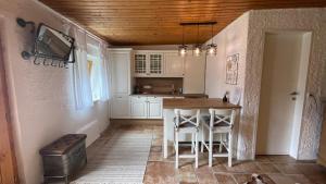 PöttelsdorfCharmantes Cottage Appartement的厨房配有桌椅和电视。