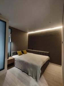リヴィウにあるДизайнерські 2 кімнатні апартаменти Стрийськаのベッドルーム1室(大型ベッド1台、黄色い枕付)