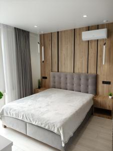 リヴィウにあるДизайнерські 2 кімнатні апартаменти Стрийськаの大きなベッドと木製の壁が備わるベッドルーム1室が備わります。