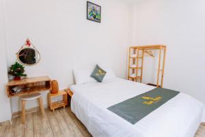 Un dormitorio con una cama blanca y un árbol de Navidad. en TamThuanHome, en Nha Trang