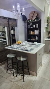 eine Küche mit einer Insel mit zwei Hockern darin in der Unterkunft Rose Cottage in Pretoria