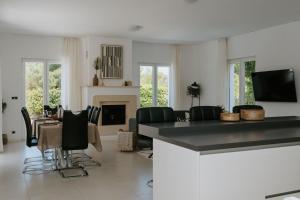 a living room with a table and chairs and a fireplace at Villa Aurelia by Domus Mirus - Rooftop Cinema & Pool & 6 Minute Walk to Beach in Splitska