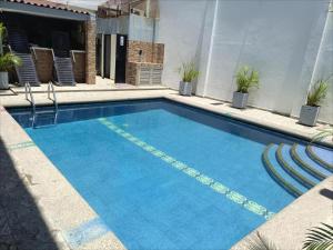 a swimming pool with blue water in a building at Hotel Velero Guajira Real in Fonseca