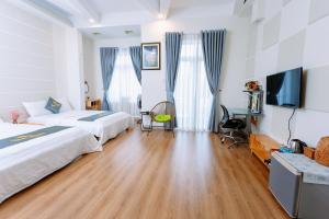 Una habitación de hotel con dos camas y un escritorio. en TamThuanHome, en Nha Trang