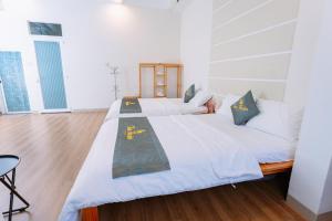 1 dormitorio grande con 2 camas y suelo de madera en TamThuanHome, en Nha Trang