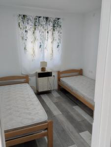 a room with two beds and a table in it at House&mini-Camp SKELICA in Neštin