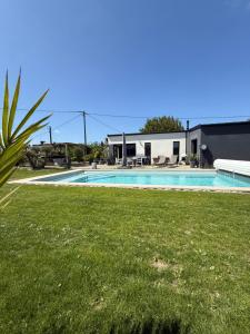 a swimming pool in front of a house at Maison à 5 minutes des plages in Lantic