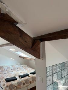 a bed in a room with wooden beams at Cosy Appartement proche de Paris in Villeneuve-Saint-Georges