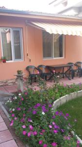 a patio with tables and chairs and purple flowers at Studio Stonel in Veliko Tŭrnovo
