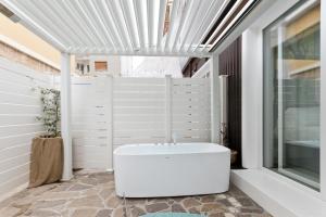 a white tub in a bathroom with a window at Borgo Centrale Rooms in Pescara +66 photos
