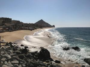 plaża z kamieniami, ocean i budynki w obiekcie Three Bedroom Villa - Waldorf Astoria Los Cabos Pedregal w mieście Cabo San Lucas