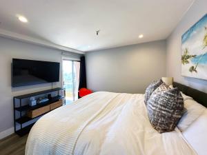 a bedroom with a bed and a flat screen tv at 2 bed 2 bath penthouse condo with AC and Ocean Views in San Diego