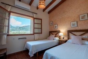 twee bedden in een kamer met een raam bij Cas Colector in Selva +23 foto's