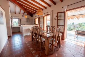 een keuken en eetkamer met een houten tafel en stoelen bij Cas Colector in Selva