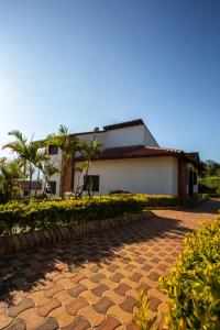 a house with a cobblestone driveway in front of it at Condominio Parque Baviera in Barichara