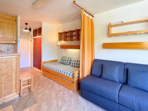 a living room with a blue couch in a room at Studio pour 3 avec balcon sud, au pied des pistes, Les Belleville - FR-1-452-191 in Les Menuires