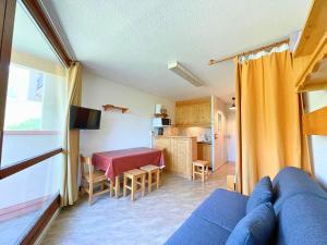 a living room with a blue couch and a kitchen at Studio pour 3 avec balcon sud, au pied des pistes, Les Belleville - FR-1-452-191 in Les Menuires