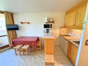 a small kitchen with a small table in a room at Studio pour 3 avec balcon sud, au pied des pistes, Les Belleville - FR-1-452-191 in Les Menuires