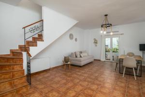 a living room with a staircase and a couch and a table at Aphrodite's Child Milos Maisonette in Adamantas