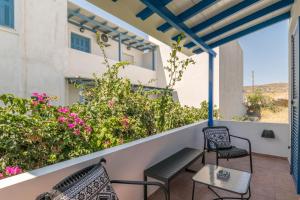 a balcony with two chairs and a table at Aphrodite's Child Milos Maisonette in Adamantas