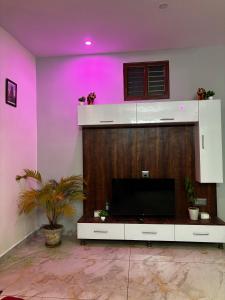 a living room with a tv and a purple wall at Sihi 3bhk Homestay in Jāmb