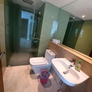 a bathroom with a sink and a toilet and a mirror at Vortex Suites Dream By KL in Kuala Lumpur