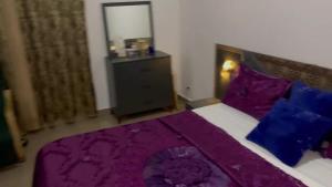 a bedroom with a bed with purple sheets and a mirror at Un Studio haut standing à Dakar plateau avec toutes les commodités in Dakar