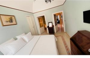 a white bed in a room with a tv at apt via cernaia rome center in Rome