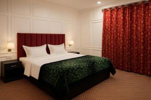 シュリーナガルにあるKoh E Noshのベッドルーム(大型ベッド1台、赤いカーテン付)