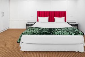 シュリーナガルにあるKoh E Noshの赤いヘッドボードが付いた大きなベッドのある寝室