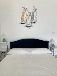 a bedroom with a bed with three sails on the wall at Casa Parthenope, a window on the sea in Naples