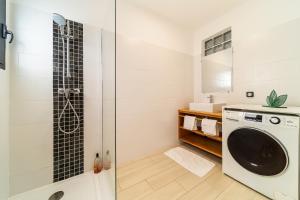 a bathroom with a washing machine and a shower at Studio Ô Calm - Confort & sérénité, proche aéroport in Saint-Denis