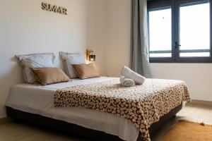 a bedroom with a bed with a blanket and a window at Studio Ô Calm - Confort & sérénité, proche aéroport in Saint-Denis