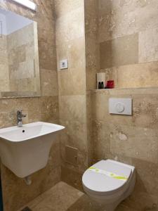 ein Badezimmer mit Waschbecken und Toilette in der Unterkunft Hotel Victoria in Costinești + 8 Fotos
